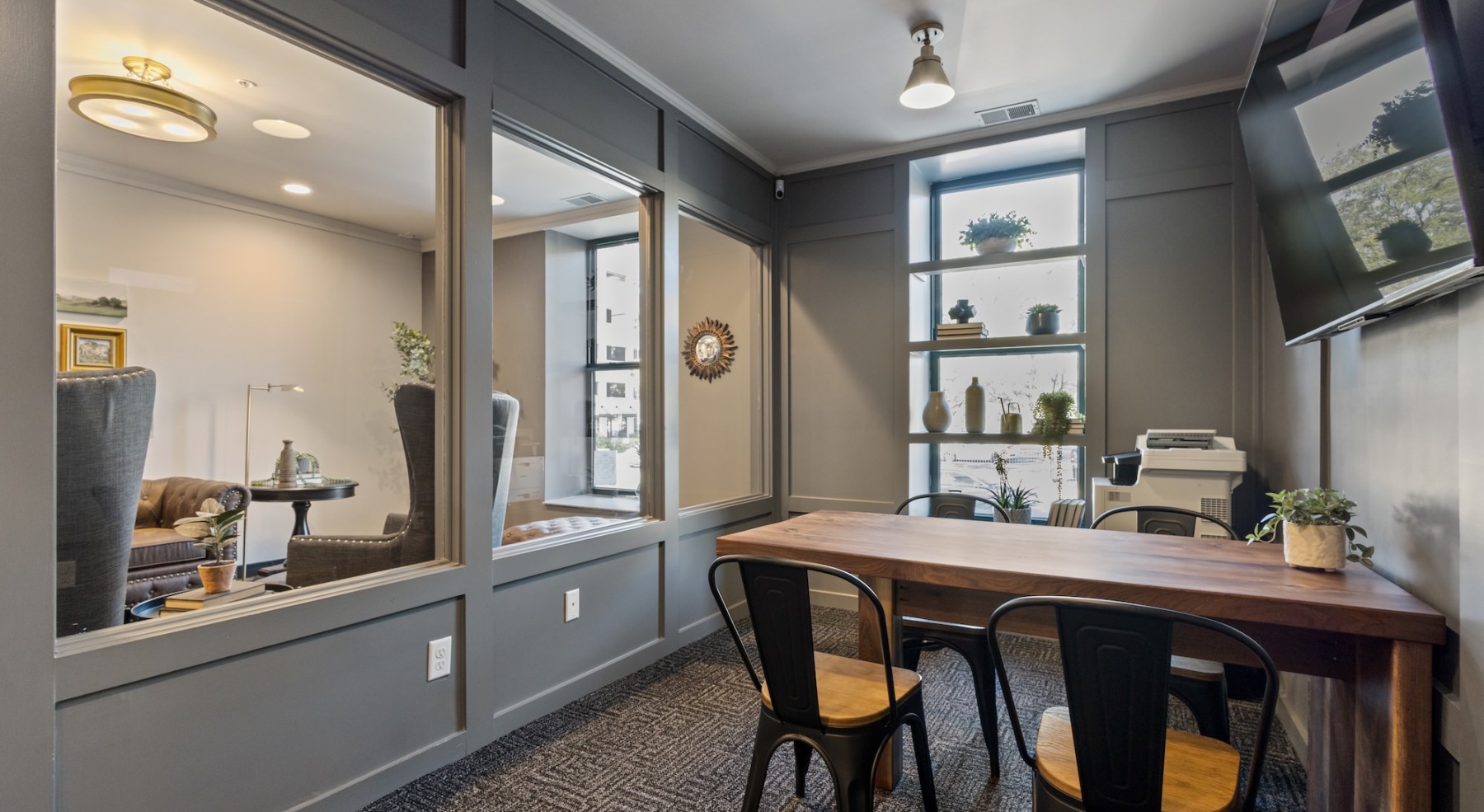 a spacious room with a table, chairs, and a large window