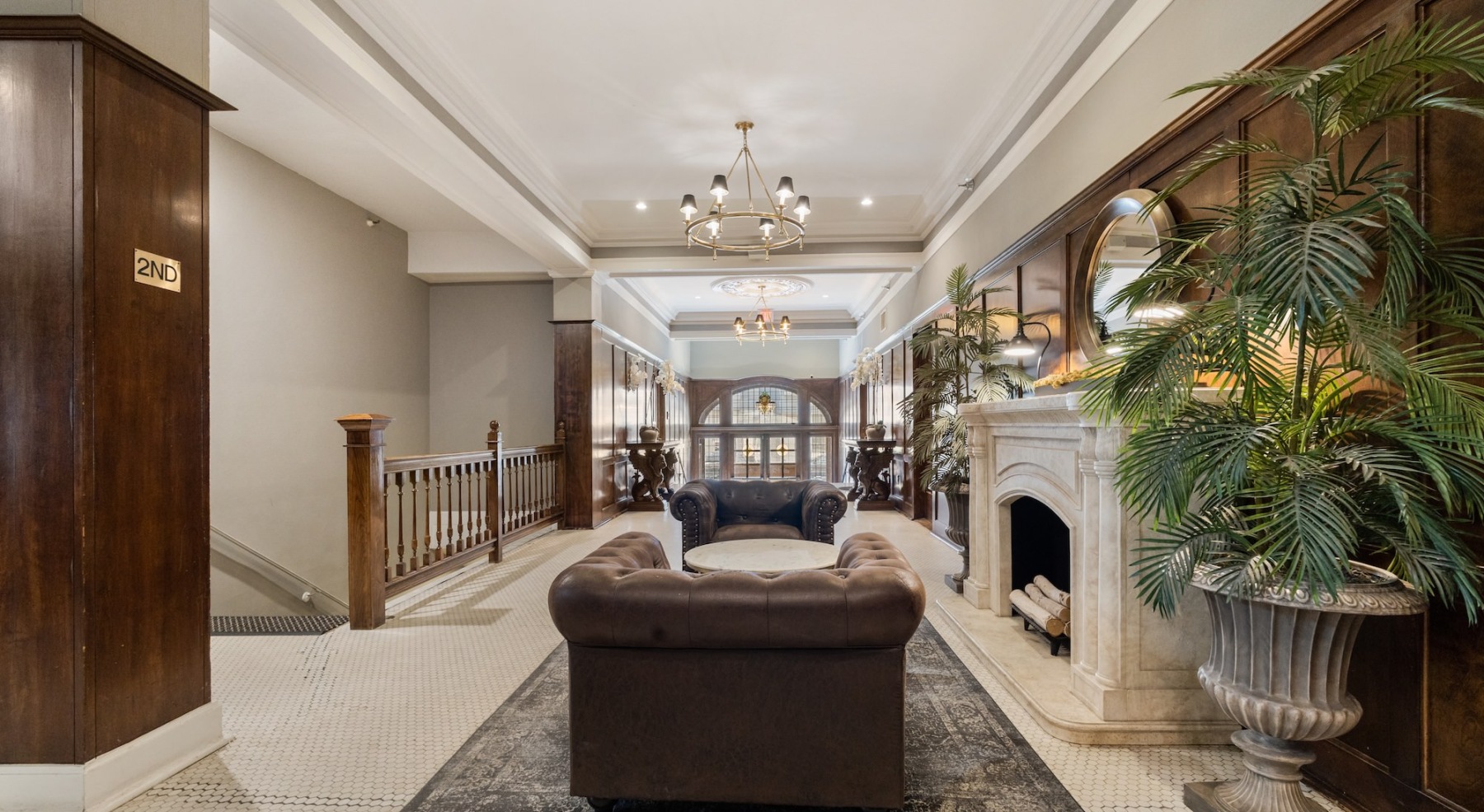 a spacious room with a fireplace, lounge seating and a rug