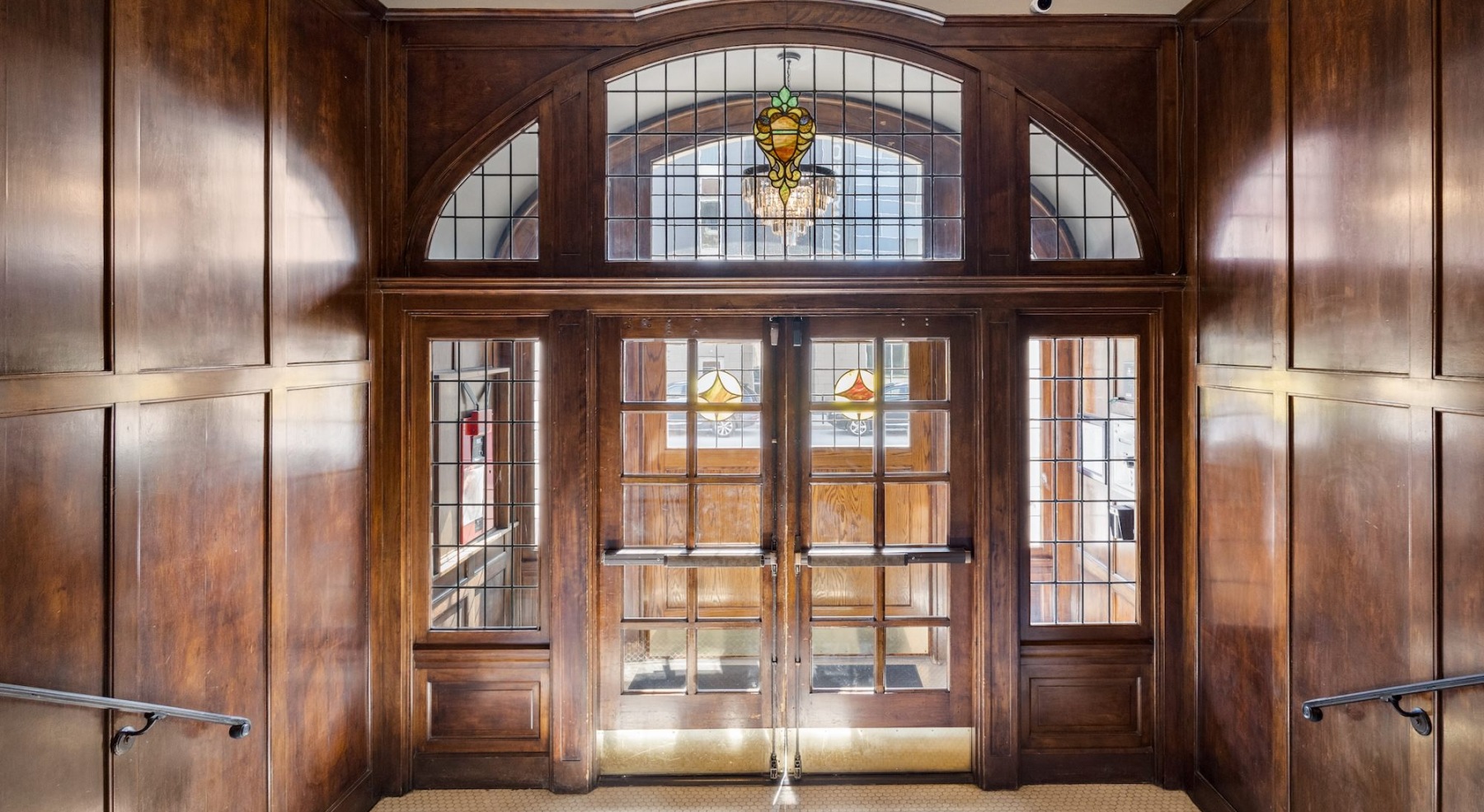 an entry with a large door and stained glass