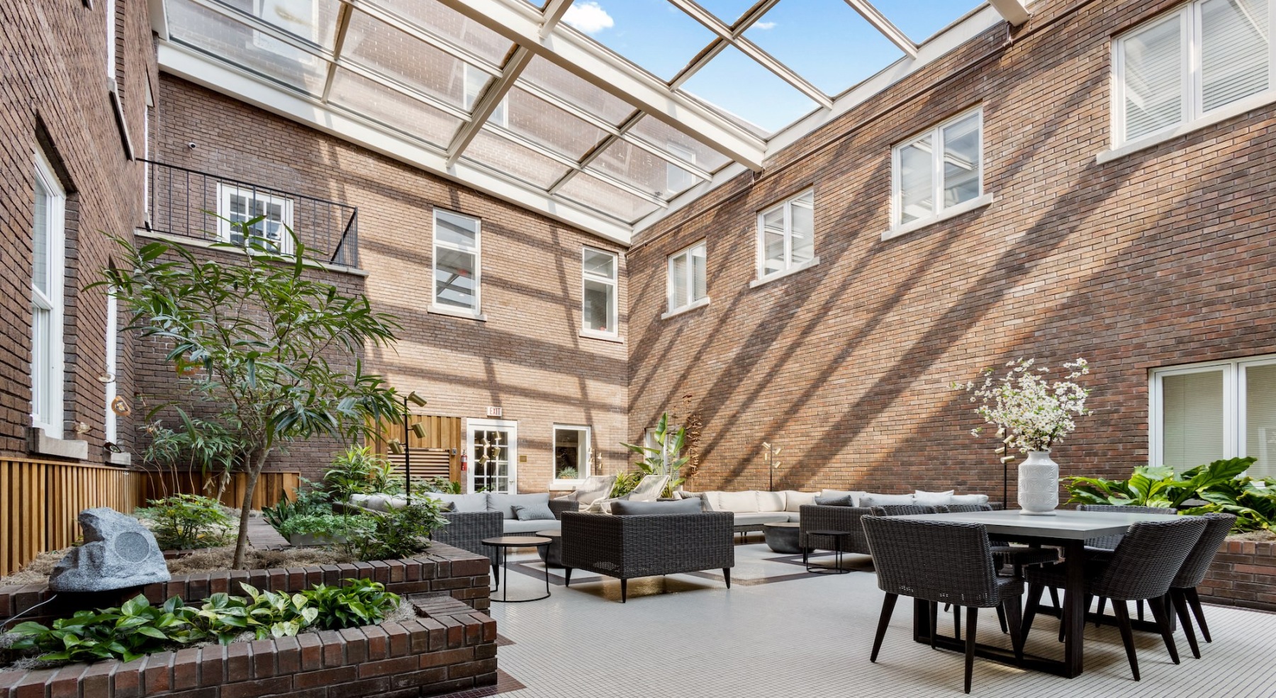 a spacious courtyard with tables, chairs and plants