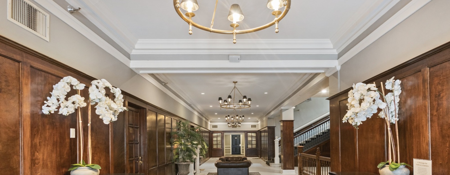 a spacious room with rugs, tile and a large staircase