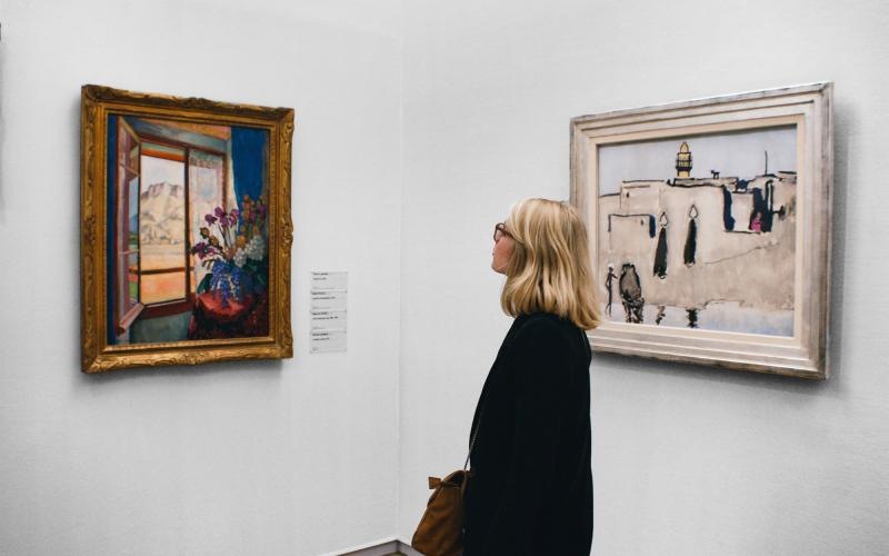 a person looking at art on the wall